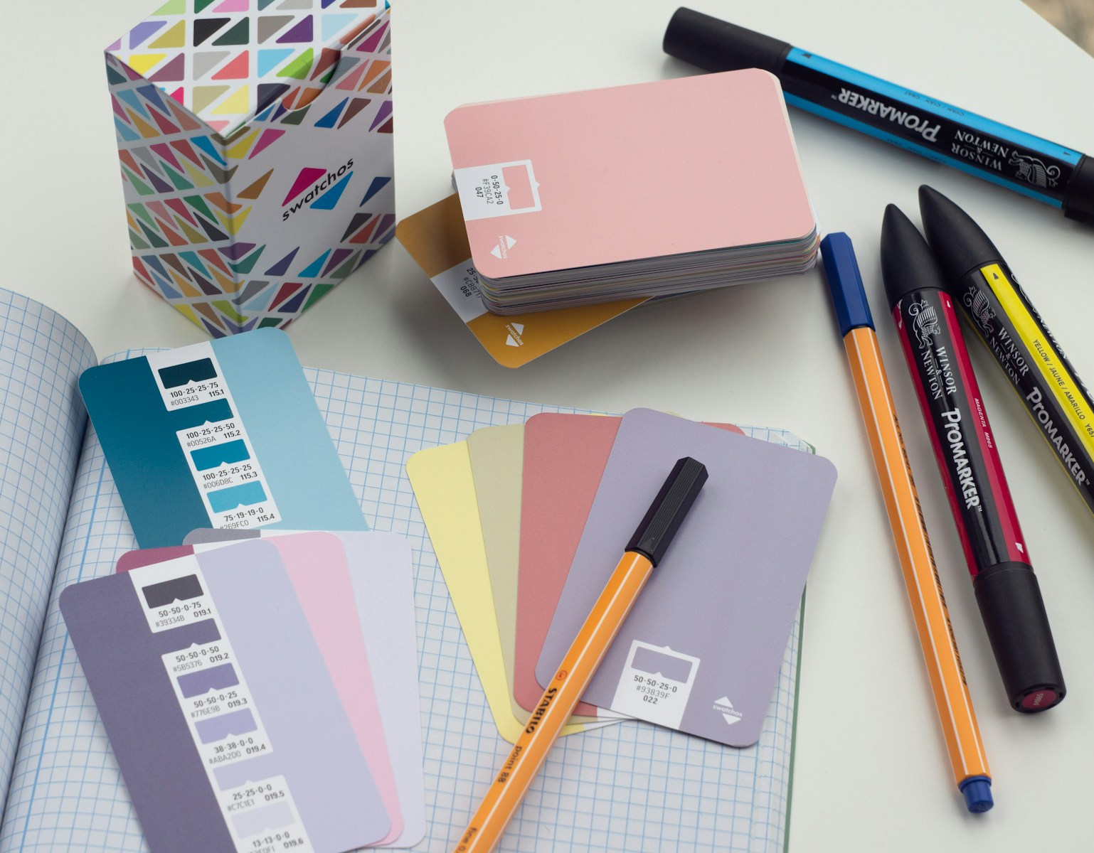 a bunch of pens and notebooks on a table